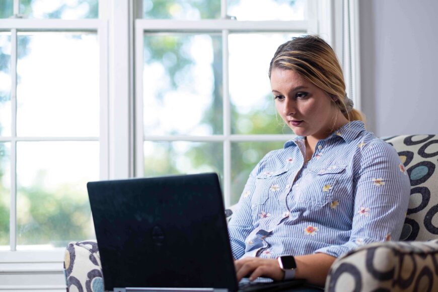 woman in armchair looking at laptop