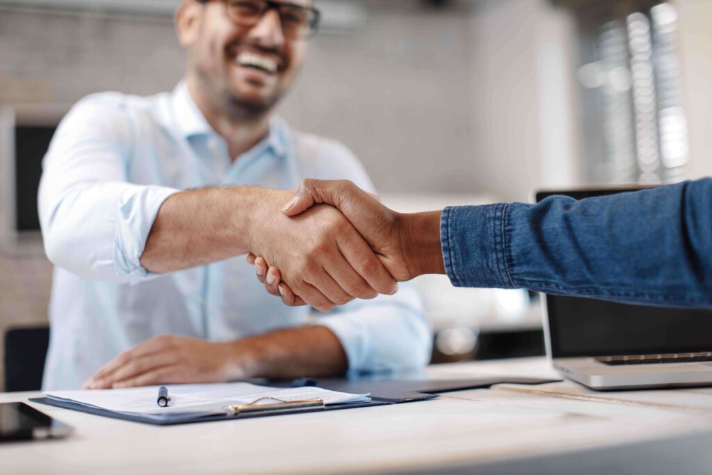 male professional shaking hands with another person over a table