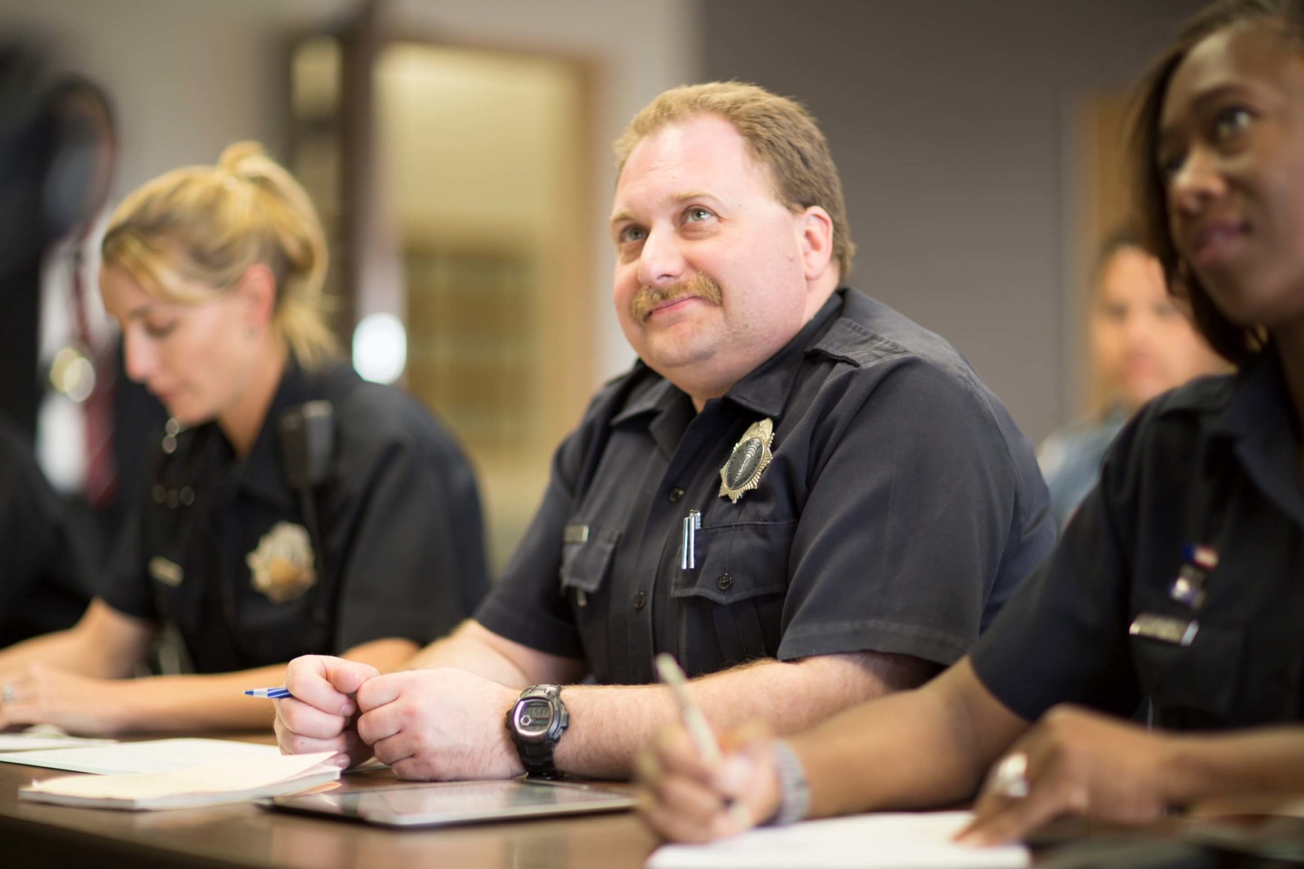 three police officers at a table in training