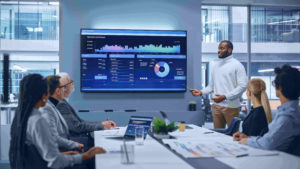 group of professionals around conference table watching a presenter