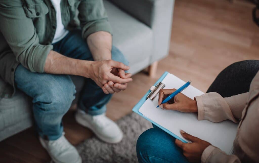 Forensic psychologist talking with a client and writing down notes