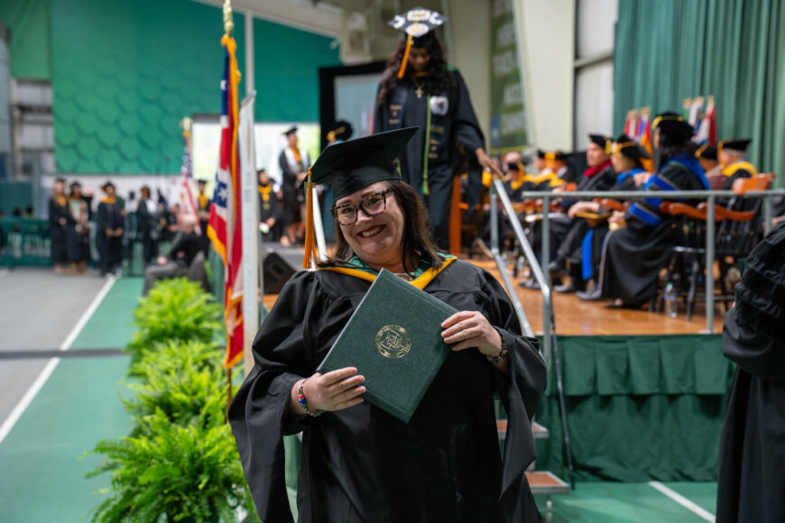 graduate posing with diploma