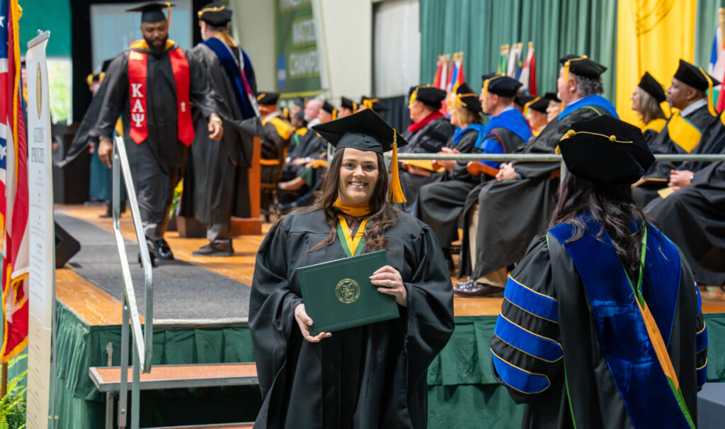 graduate posing with diploma