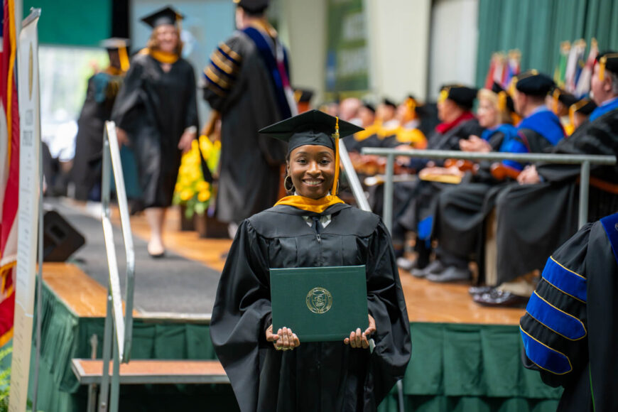 graduate posing with diploma