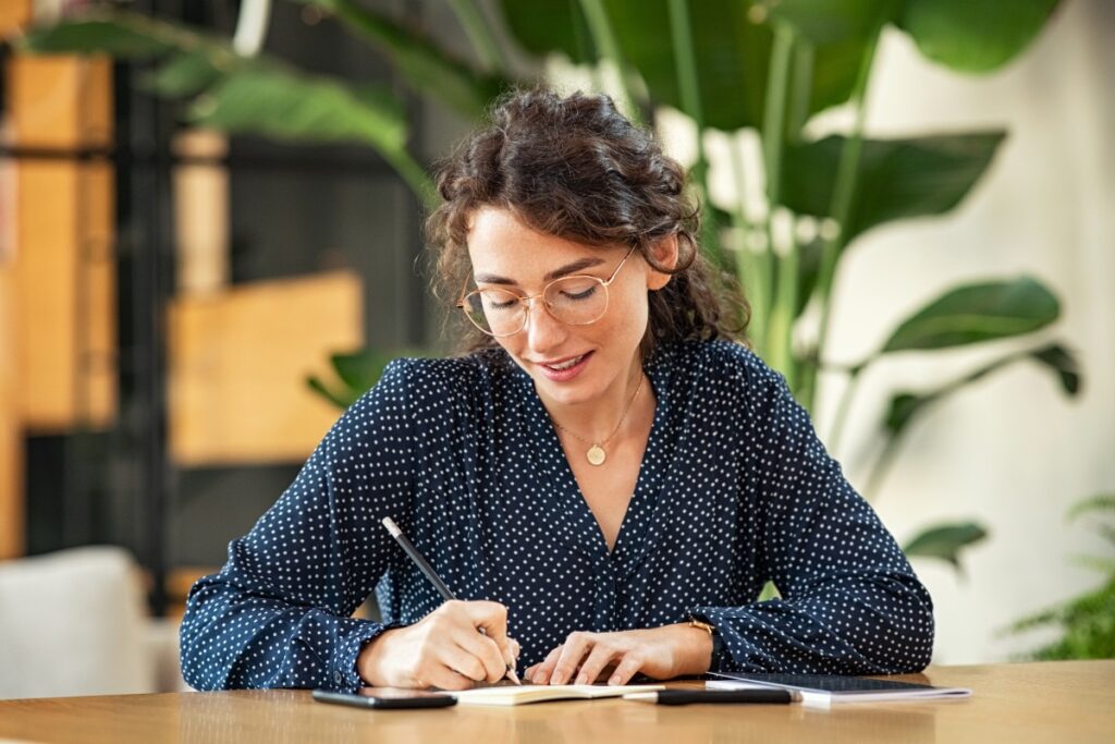 Master's degree student writing in a notebook