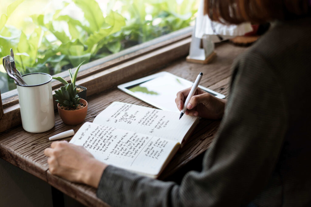 person journaling near window