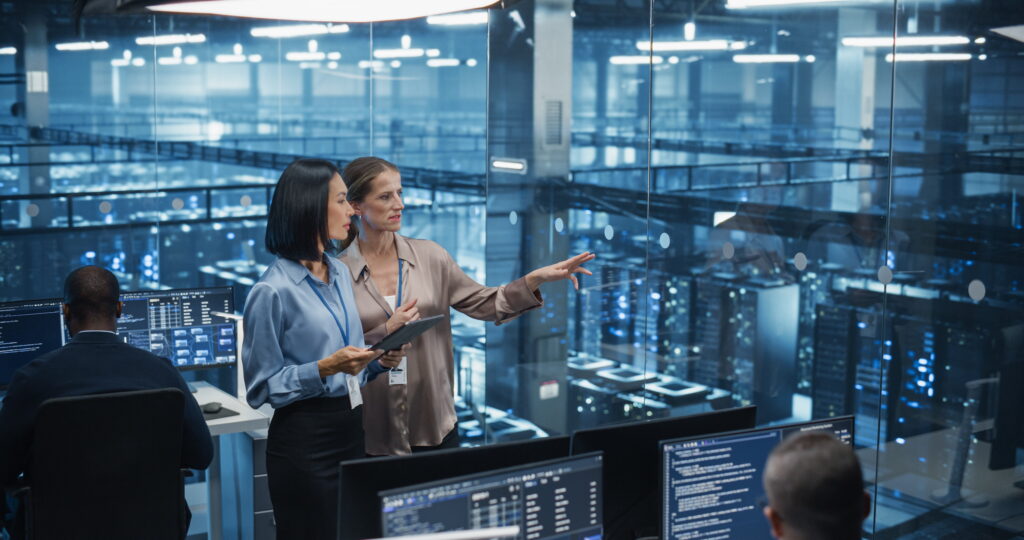 two women with master's degrees in AI working in a data center