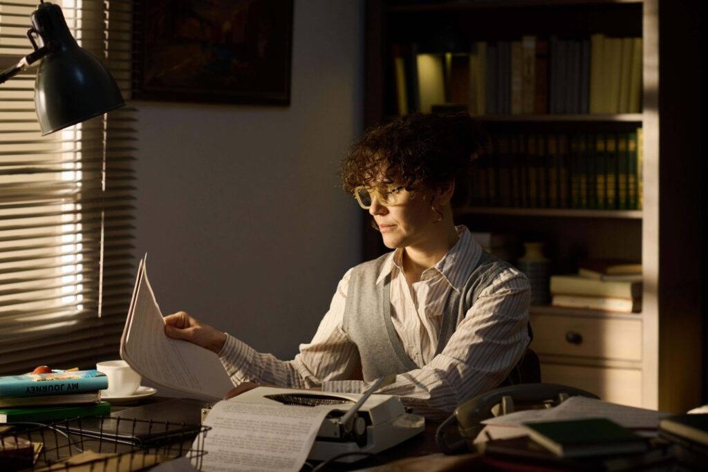 Writer with a typewriter at a desk working a rhetoric and composition job